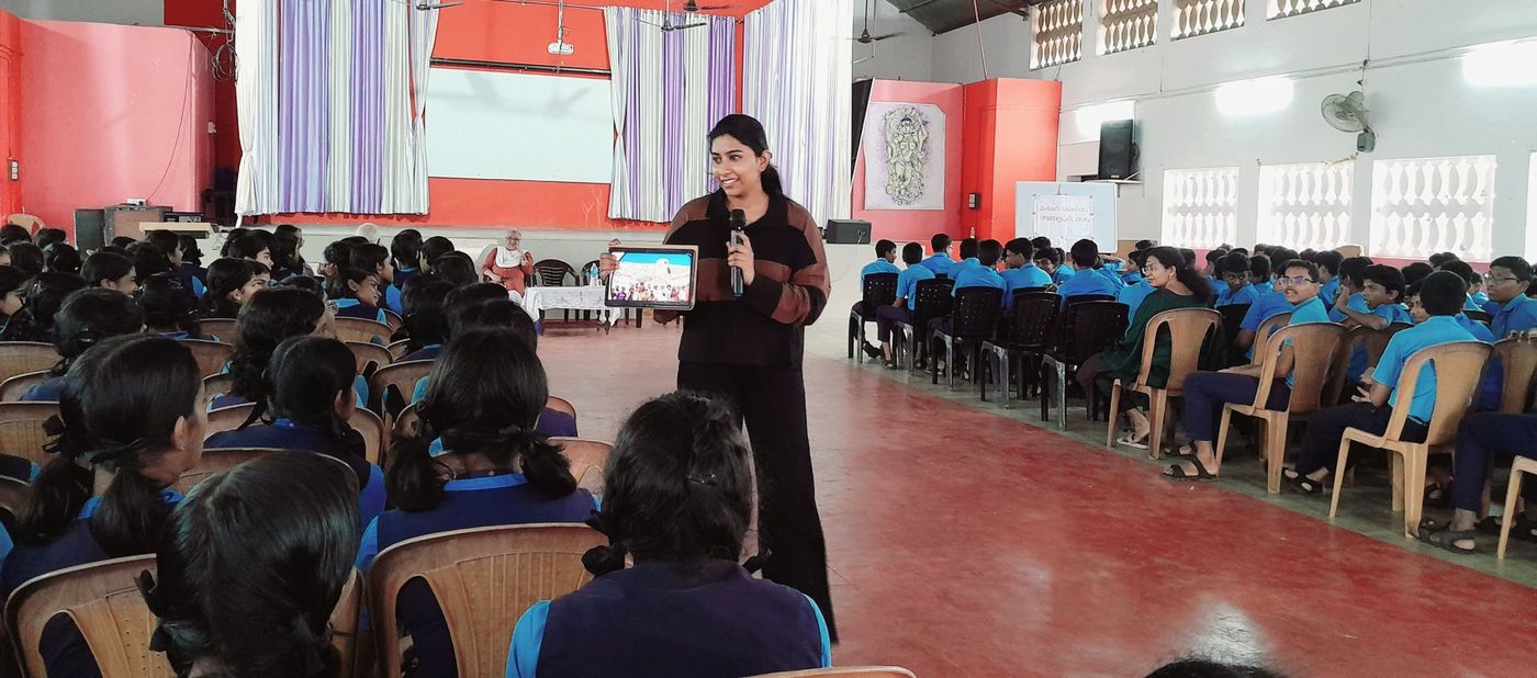 Gouri speaking to students in a school hall